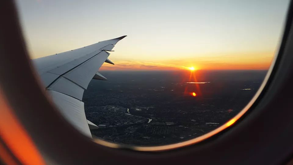The wing of an airplane seen from the inside of a cabin. Photo: Eva Darron/Unsplash 