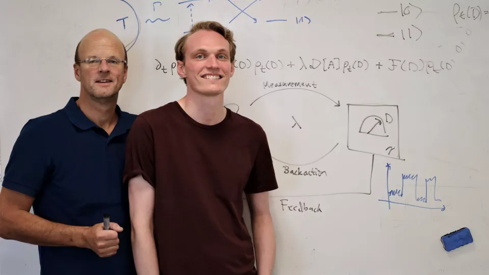 Forskarna Peter Samuelsson och Björn Annby-Andersson framför en tavla som visar den nya ekvationen. Foto: Johan Lindskoug