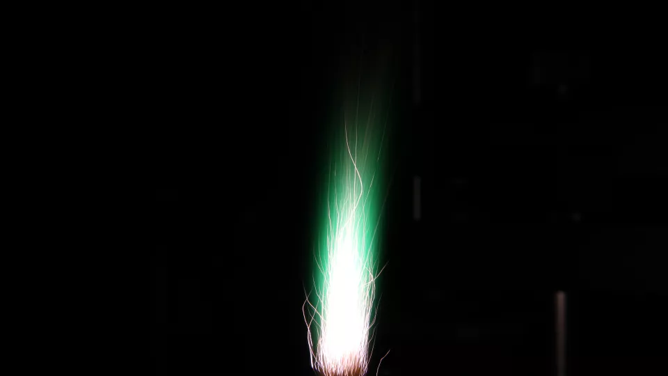 Eldslåga mot mörk bakgrund. Aluminiumpulver som brinner. Lite koppar slank med, och färgar lågan grön. Foto: Zhongshan Li 