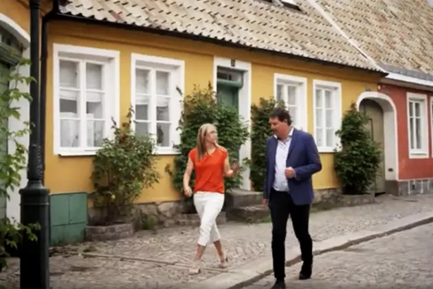 Maria Messing och Johan Wester promenerar på en vacker gata i Lund. 