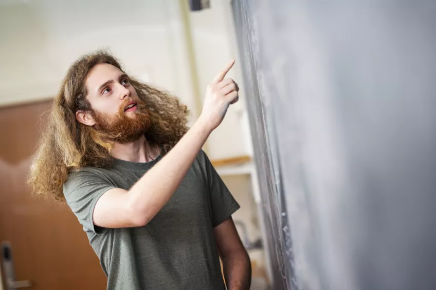 Student visar en matematisk formel på en svart tavla. Foto: Johan Persson